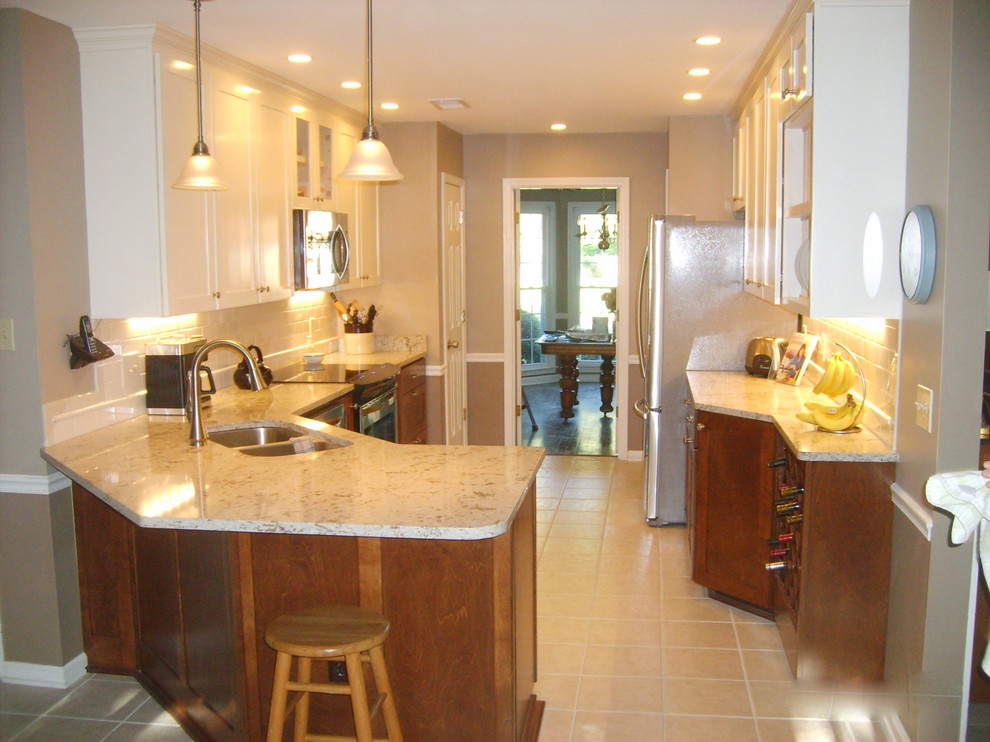Eat-in kitchen - transitional galley eat-in kitchen idea with an undermount sink, shaker cabinets, dark wood cabinets, quartz countertops, white backsplash, subway tile backsplash and stainless steel appliances