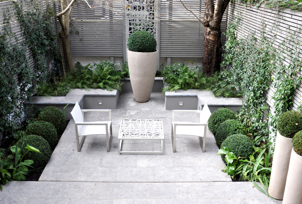 Example of a small minimalist stone patio container garden design in London