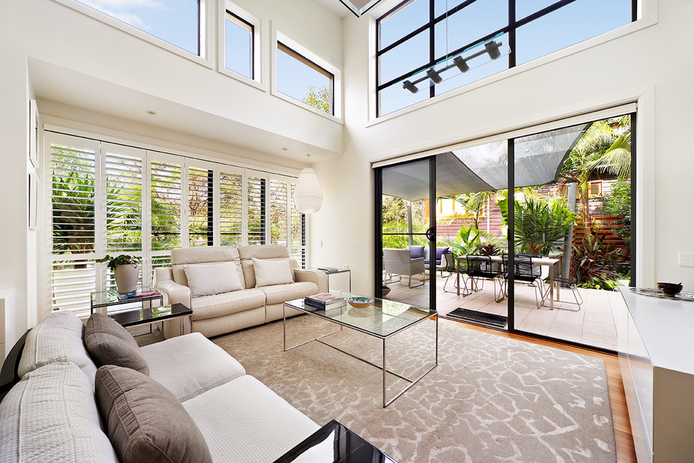 This is an example of a contemporary formal living room in Sydney with white walls, medium hardwood floors and no tv.