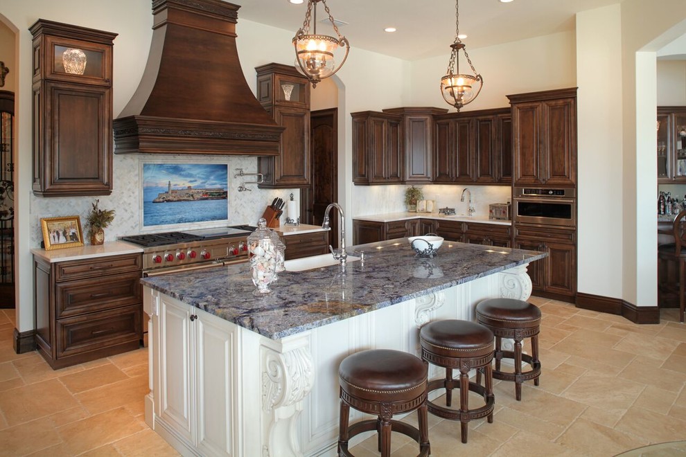 Inspiration for a large mediterranean u-shaped open plan kitchen in Tampa with raised-panel cabinets, brown cabinets, granite benchtops, beige splashback, stone tile splashback, panelled appliances, travertine floors and with island.