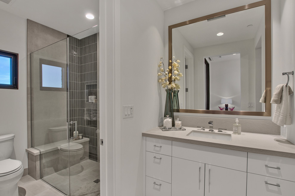 Alcove shower - mid-sized contemporary 3/4 gray tile and cement tile alcove shower idea in Phoenix with flat-panel cabinets, white cabinets, white walls, an undermount sink, quartz countertops, a hinged shower door and beige countertops
