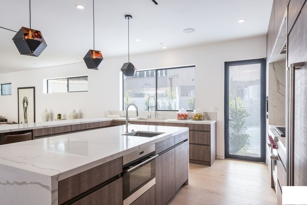 Design ideas for a mid-sized modern u-shaped open plan kitchen in Los Angeles with an undermount sink, flat-panel cabinets, medium wood cabinets, marble benchtops, white splashback, window splashback, stainless steel appliances, light hardwood floors, with island, brown floor and white benchtop.