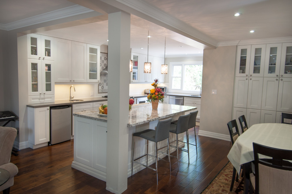 Large transitional u-shaped medium tone wood floor eat-in kitchen photo in Toronto with a double-bowl sink, shaker cabinets, white cabinets, quartzite countertops, white backsplash, ceramic backsplash, stainless steel appliances and an island