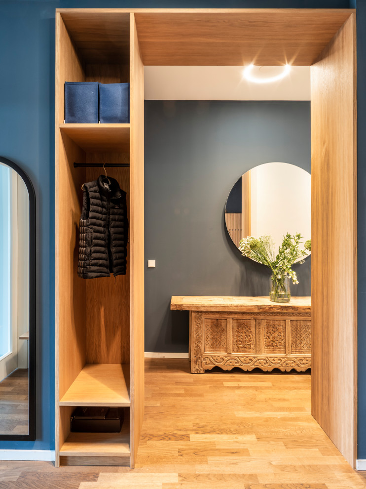 Mittelgroßer Moderner Schmaler Flur mit blauer Wandfarbe, gebeiztem Holzboden, beigem Boden und Holzwänden in Berlin