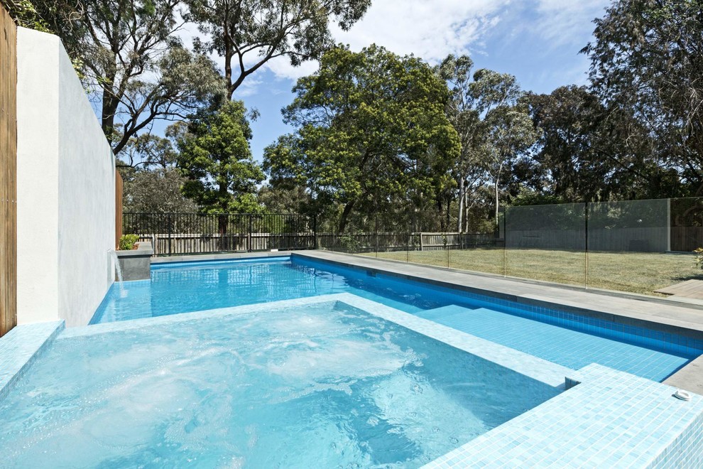 Mid-sized contemporary backyard custom-shaped pool in Melbourne with a hot tub and concrete pavers.