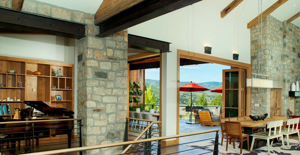 This is an example of a modern open concept living room in Denver with white walls, dark hardwood floors, a standard fireplace and a stone fireplace surround.