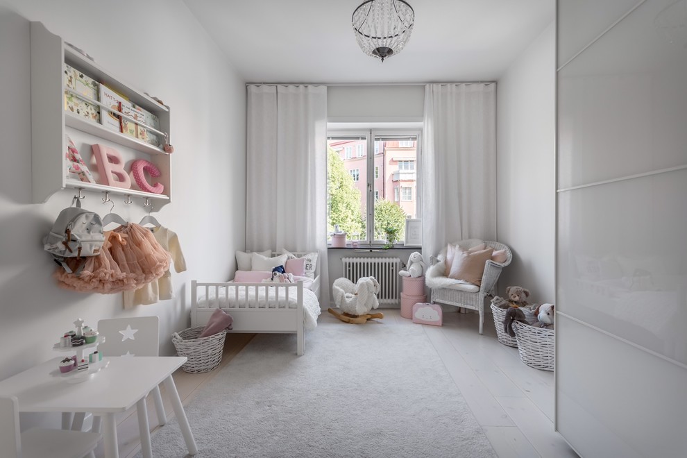 Design ideas for a scandinavian kids' bedroom for girls in Stockholm with white walls, painted wood floors and white floor.