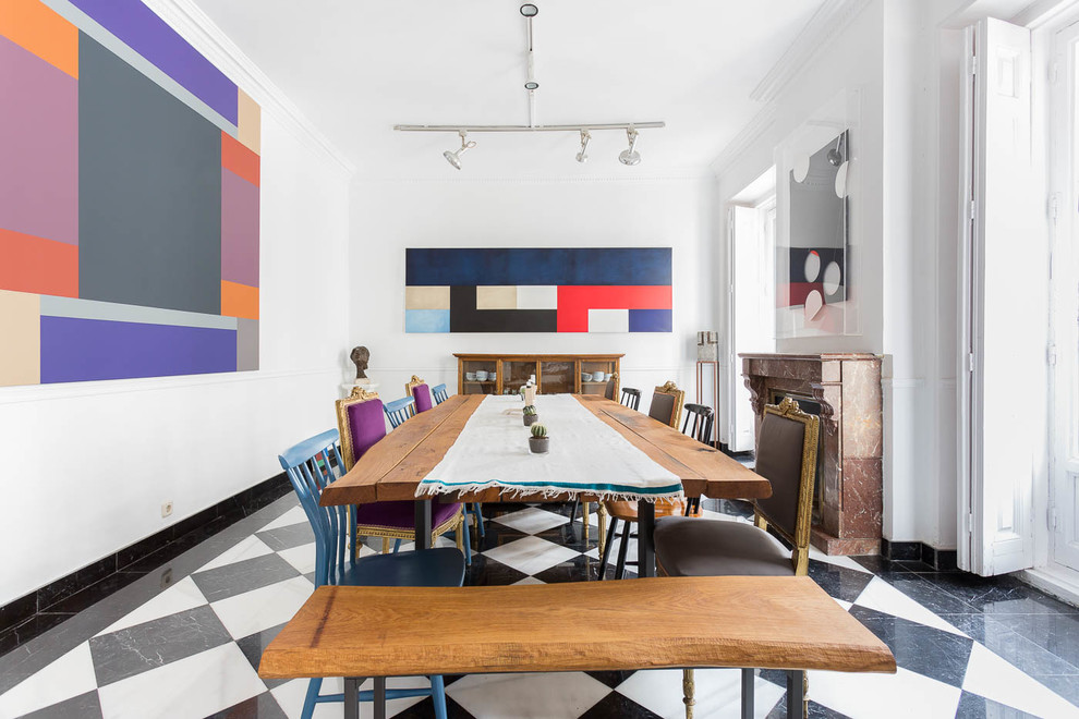 Inspiration for a large eclectic dining room in Madrid with white walls, porcelain floors, a standard fireplace, a stone fireplace surround and multi-coloured floor.