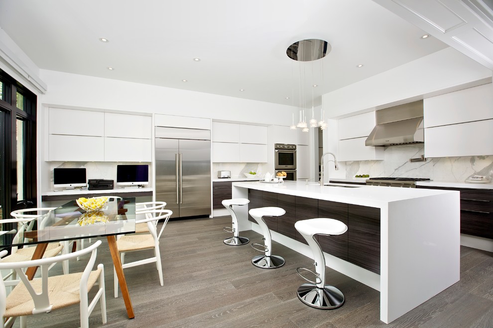 Design ideas for a contemporary l-shaped eat-in kitchen in Toronto with an undermount sink, flat-panel cabinets, white cabinets, solid surface benchtops, white splashback, stone slab splashback and stainless steel appliances.
