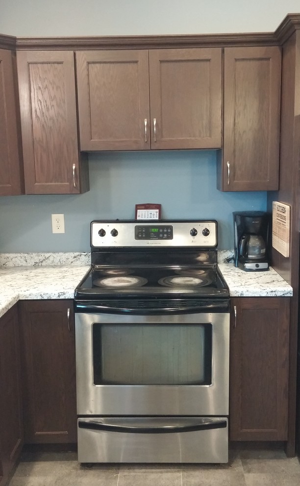 Example of a transitional l-shaped home design design with a drop-in sink, shaker cabinets, laminate countertops and an island