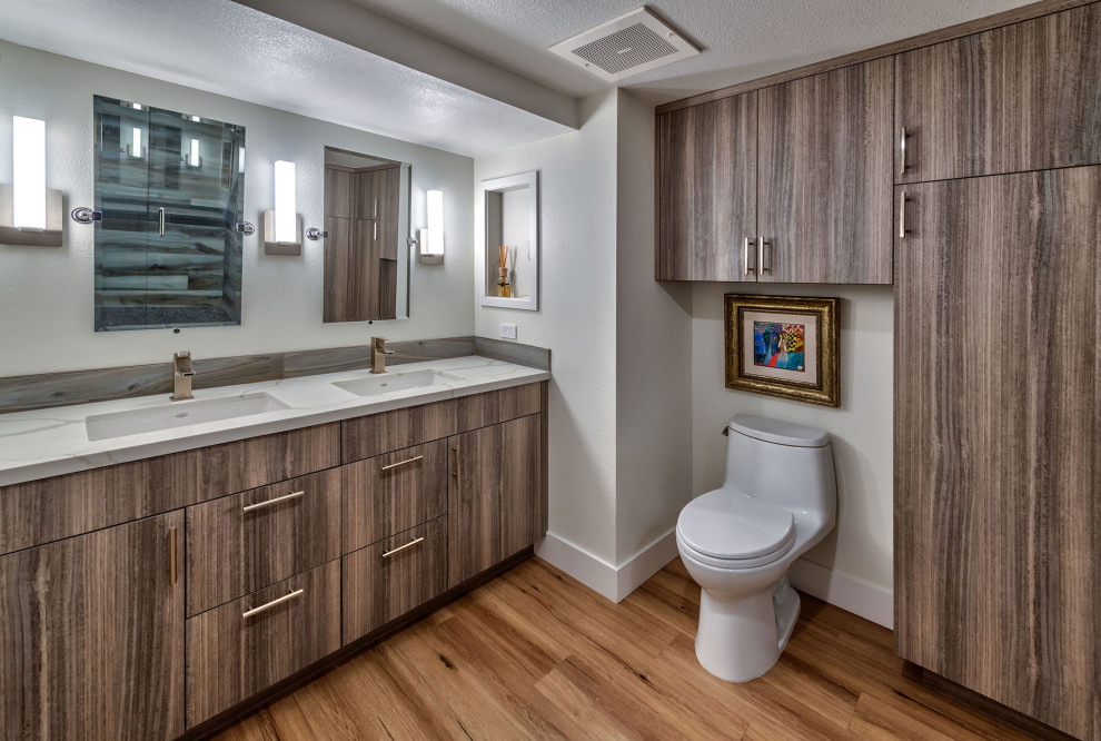 Mid-sized contemporary master bathroom in Other with flat-panel cabinets, brown cabinets, a built-in vanity, a one-piece toilet, white tile, white walls, wood-look tile, a drop-in sink, quartzite benchtops, brown floor, beige benchtops and a double vanity.