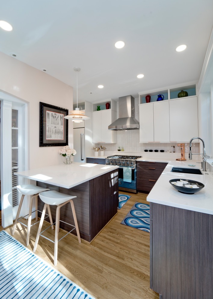Example of a mid-sized 1950s l-shaped light wood floor and brown floor eat-in kitchen design in DC Metro with an undermount sink, flat-panel cabinets, dark wood cabinets, quartz countertops, white backsplash, subway tile backsplash, paneled appliances, a peninsula and white countertops