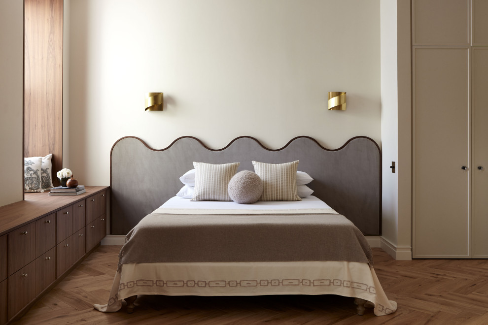 Modern inredning av ett sovrum, med beige väggar, ljust trägolv och beiget golv