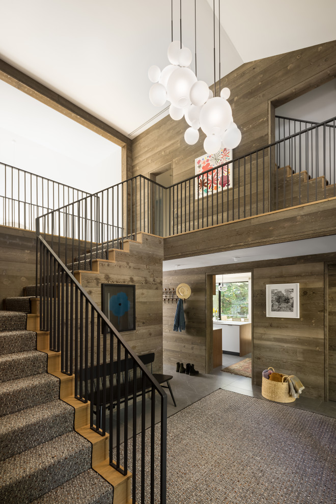 Foyer - contemporary gray floor and wood wall foyer idea with brown walls