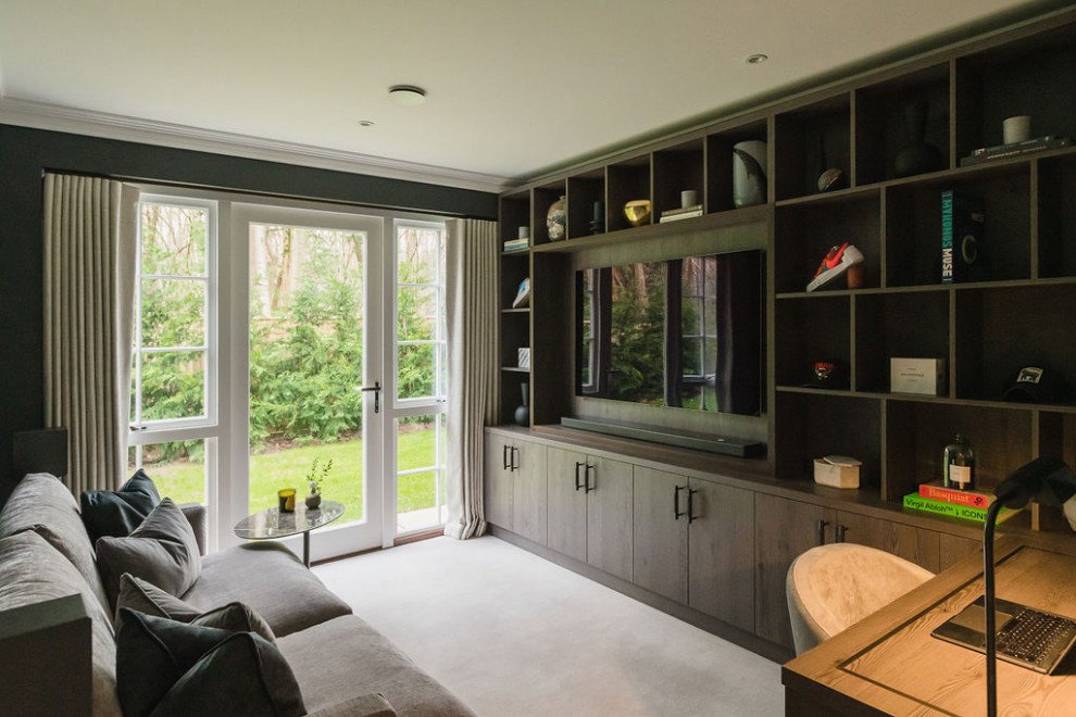This is an example of a mid-sized contemporary family room in Surrey with a game room, black walls, carpet, a built-in media wall and grey floor.