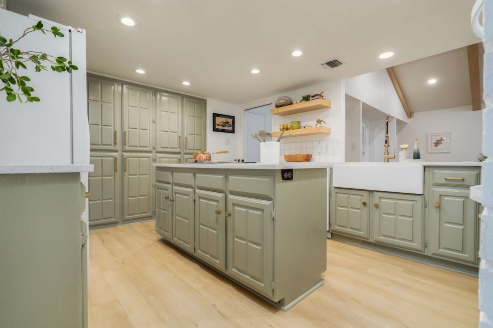 Kitchen - mid-sized modern l-shaped vinyl floor and yellow floor kitchen idea in Austin with a farmhouse sink, raised-panel cabinets, green cabinets, granite countertops, white backsplash, ceramic backsplash, white appliances, an island and white countertops