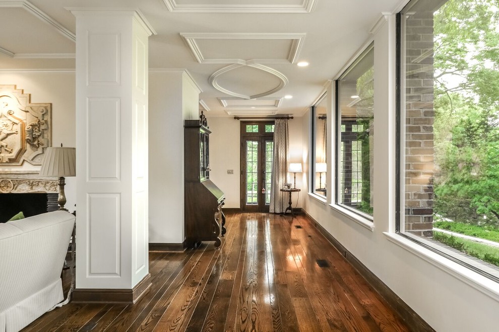 Mid-sized arts and crafts hallway in Kansas City with white walls, dark hardwood floors and brown floor.