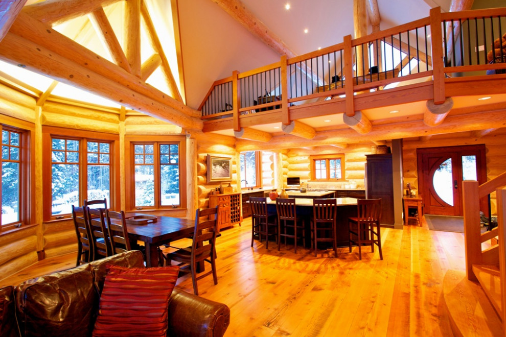 Example of a mid-sized l-shaped light wood floor and brown floor eat-in kitchen design in Vancouver with a drop-in sink, recessed-panel cabinets, dark wood cabinets, stainless steel appliances, an island and white countertops