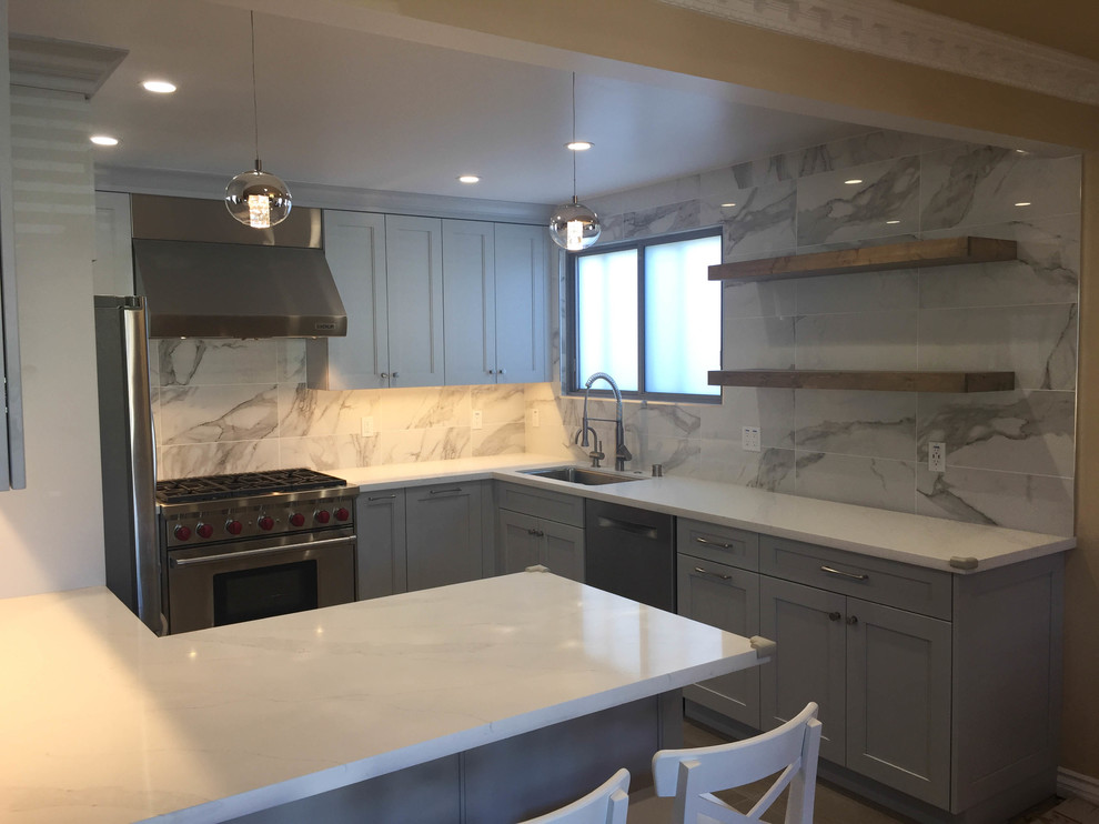 Inspiration for a mid-sized transitional u-shaped porcelain tile and gray floor eat-in kitchen remodel in San Francisco with an undermount sink, recessed-panel cabinets, gray cabinets, quartz countertops, gray backsplash, porcelain backsplash, stainless steel appliances and white countertops