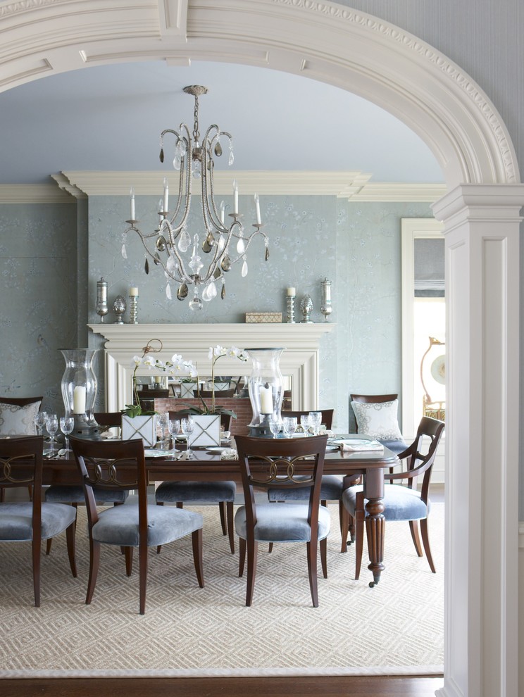 Inspiration for a large traditional separate dining room in New York with blue walls, beige floor, medium hardwood floors, a standard fireplace and a wood fireplace surround.