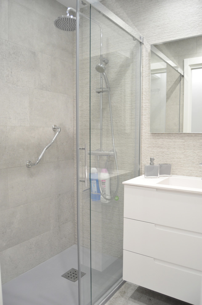 Mid-sized modern 3/4 bathroom in Bilbao with flat-panel cabinets, white cabinets, a curbless shower, a one-piece toilet, gray tile, ceramic tile, grey walls, cement tiles, a drop-in sink, engineered quartz benchtops, grey floor and a sliding shower screen.