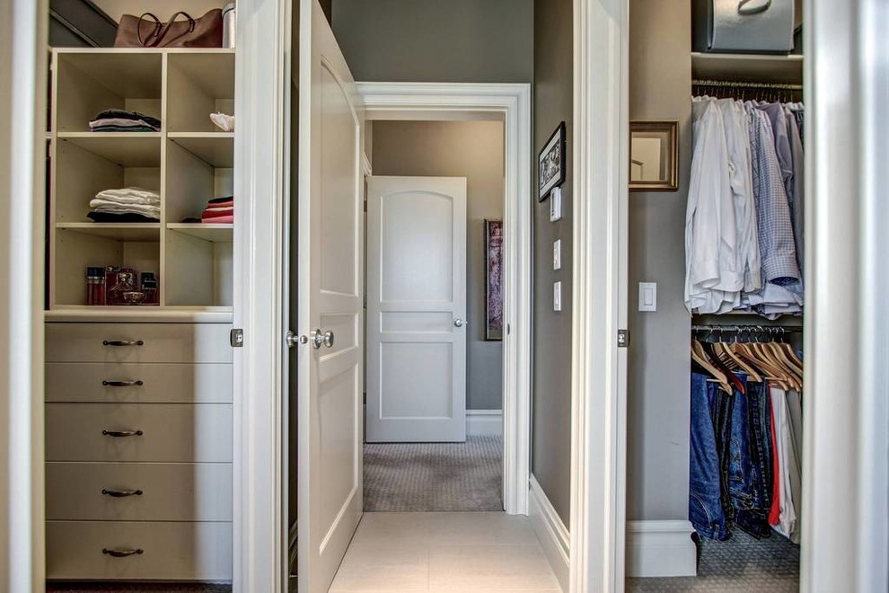 Photo of a mid-sized arts and crafts gender-neutral walk-in wardrobe in New York with flat-panel cabinets, white cabinets, carpet and beige floor.