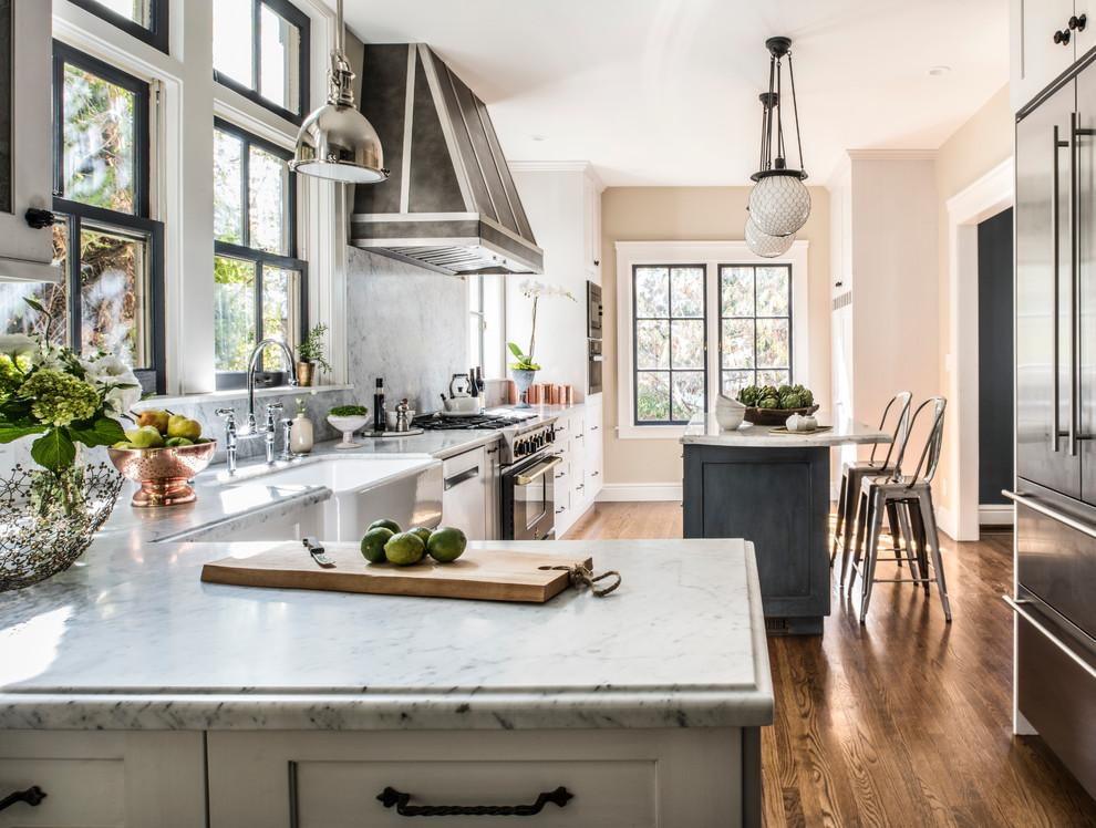 Large transitional l-shaped separate kitchen in San Francisco with a farmhouse sink, white cabinets, stainless steel appliances, dark hardwood floors, with island, shaker cabinets, marble benchtops, multi-coloured splashback and marble splashback.