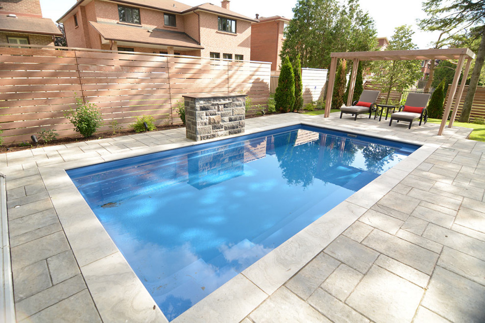 Inspiration for a mid-sized transitional backyard rectangular lap pool with natural stone pavers.