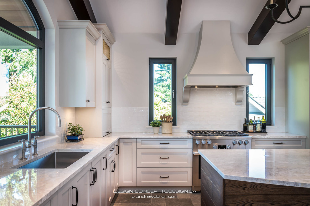 This is an example of a large mediterranean l-shaped open plan kitchen in Vancouver with a single-bowl sink, shaker cabinets, beige cabinets, granite worktops, white splashback, porcelain splashback, stainless steel appliances, limestone flooring, an island, grey floors and multicoloured worktops.