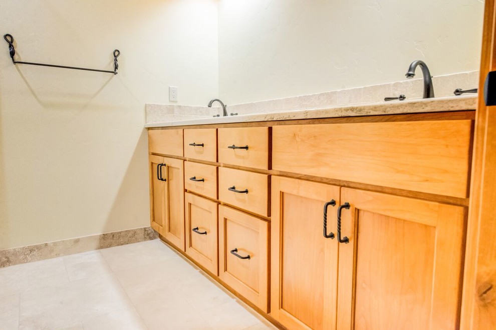 Photo of a mid-sized country master bathroom in Orange County with beaded inset cabinets, light wood cabinets, beige tile, travertine, beige walls, travertine floors, an undermount sink and engineered quartz benchtops.