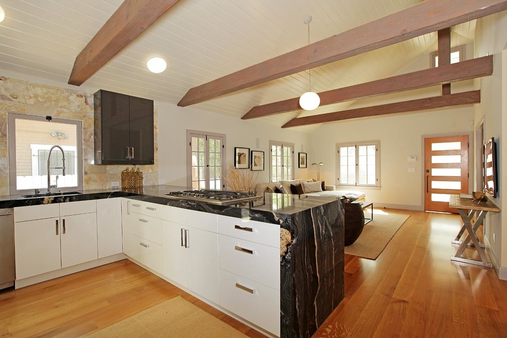 Inspiration for a contemporary u-shaped open concept kitchen remodel in Los Angeles with flat-panel cabinets, gray cabinets, beige backsplash, stone tile backsplash and stainless steel appliances