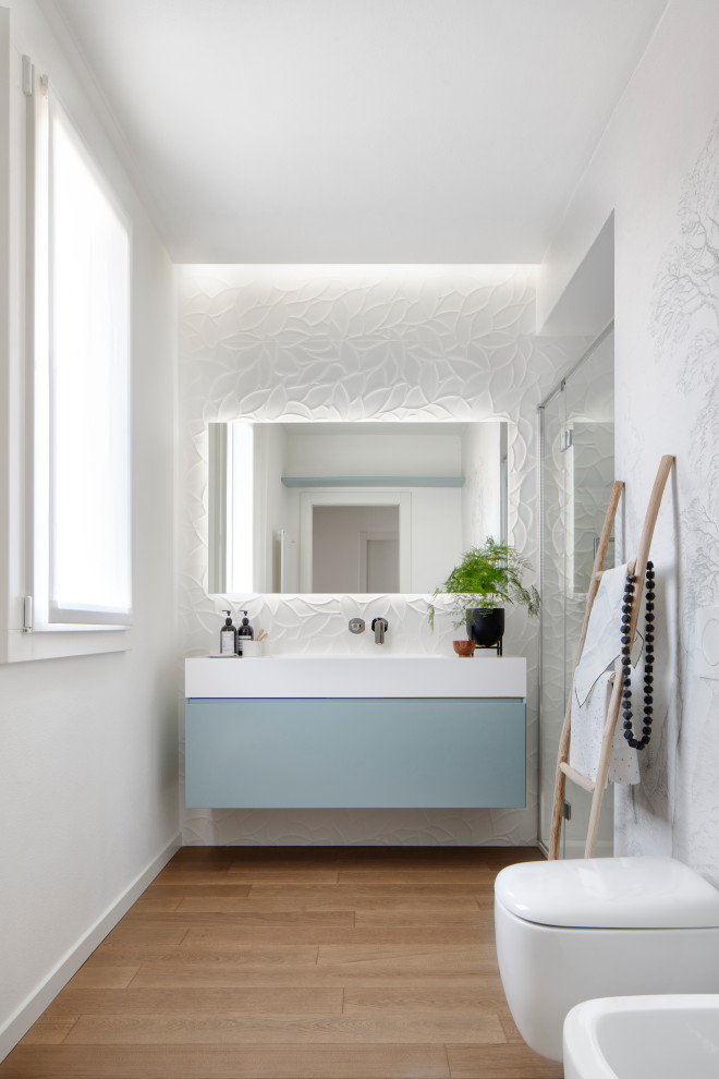 Idéer för ett mellanstort modernt badrum, med turkosa skåp, ett platsbyggt badkar, en vägghängd toalettstol, vit kakel, keramikplattor, blå väggar, mörkt trägolv och ett integrerad handfat