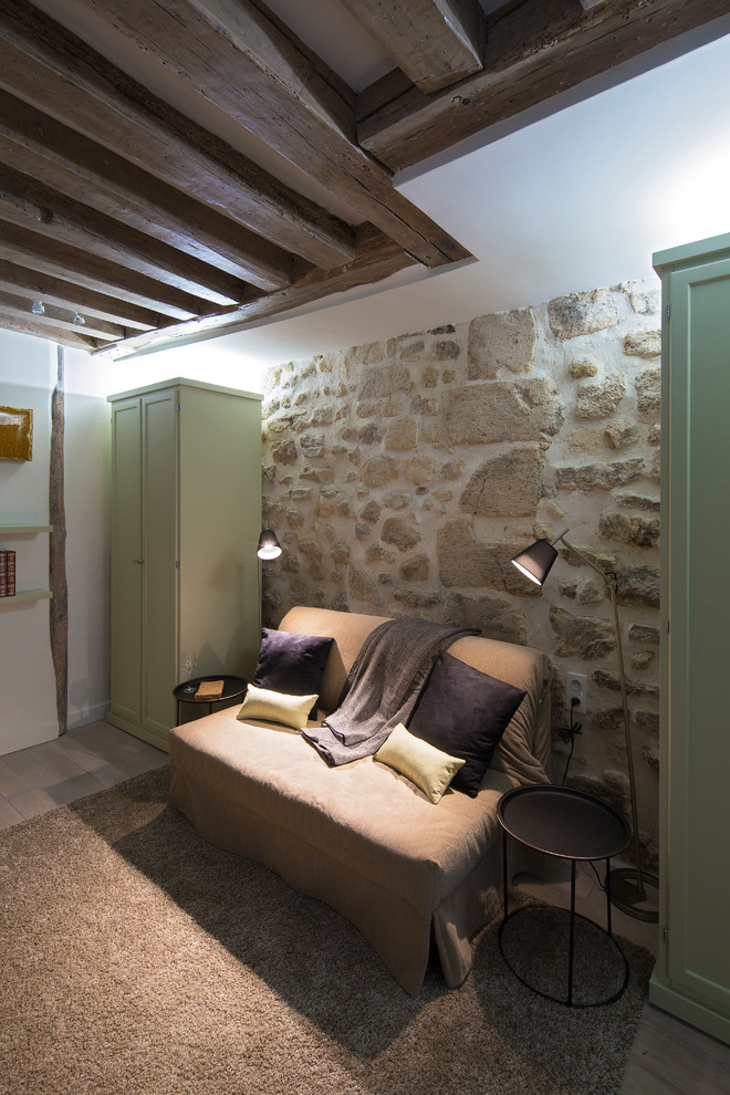 Cette image montre une petite chambre parentale minimaliste avec un mur beige, parquet clair et un sol beige.
