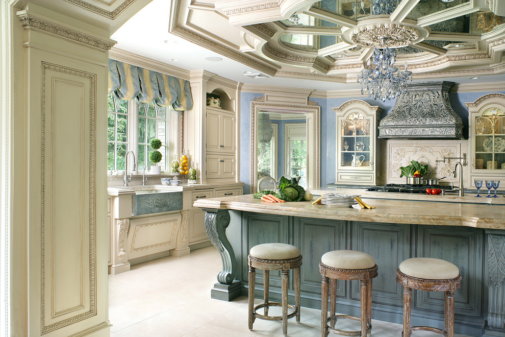 Design ideas for a large traditional u-shaped eat-in kitchen in New York with a farmhouse sink, beaded inset cabinets, beige cabinets, limestone benchtops, beige splashback, mosaic tile splashback, limestone floors and multiple islands.