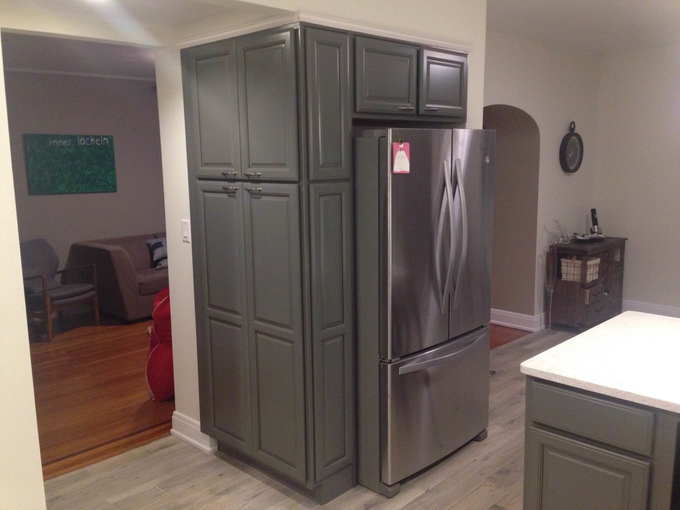 Inspiration for a small transitional u-shaped light wood floor eat-in kitchen remodel in Cincinnati with a farmhouse sink, raised-panel cabinets, gray cabinets, quartz countertops, gray backsplash, glass tile backsplash, stainless steel appliances and a peninsula