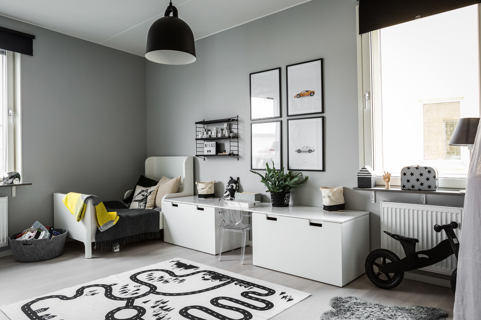 Photo of a mid-sized scandinavian gender-neutral kids' playroom for kids 4-10 years old in Stockholm with grey walls and light hardwood floors.