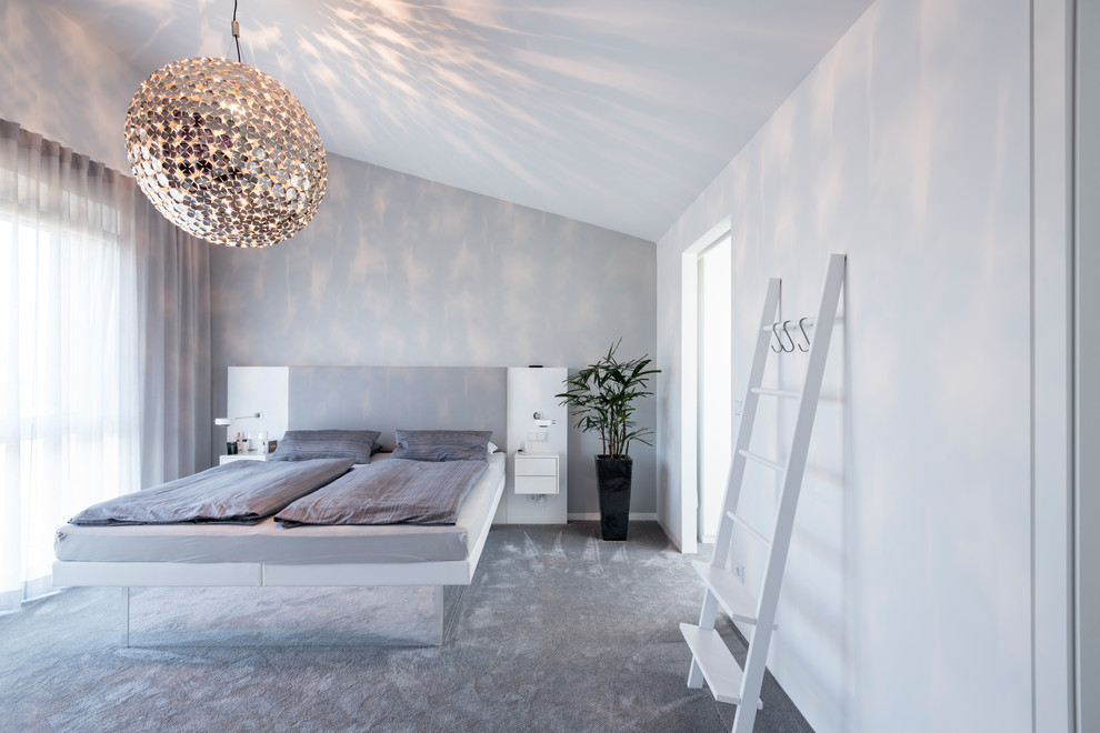 Mid-sized contemporary master bedroom in Nuremberg with white walls, carpet, no fireplace and grey floor.