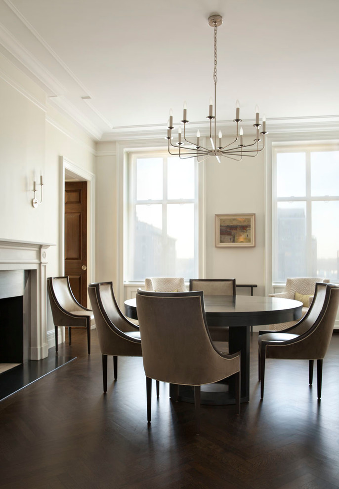 This is an example of a mid-sized traditional open plan dining in New York with white walls, dark hardwood floors and a standard fireplace.