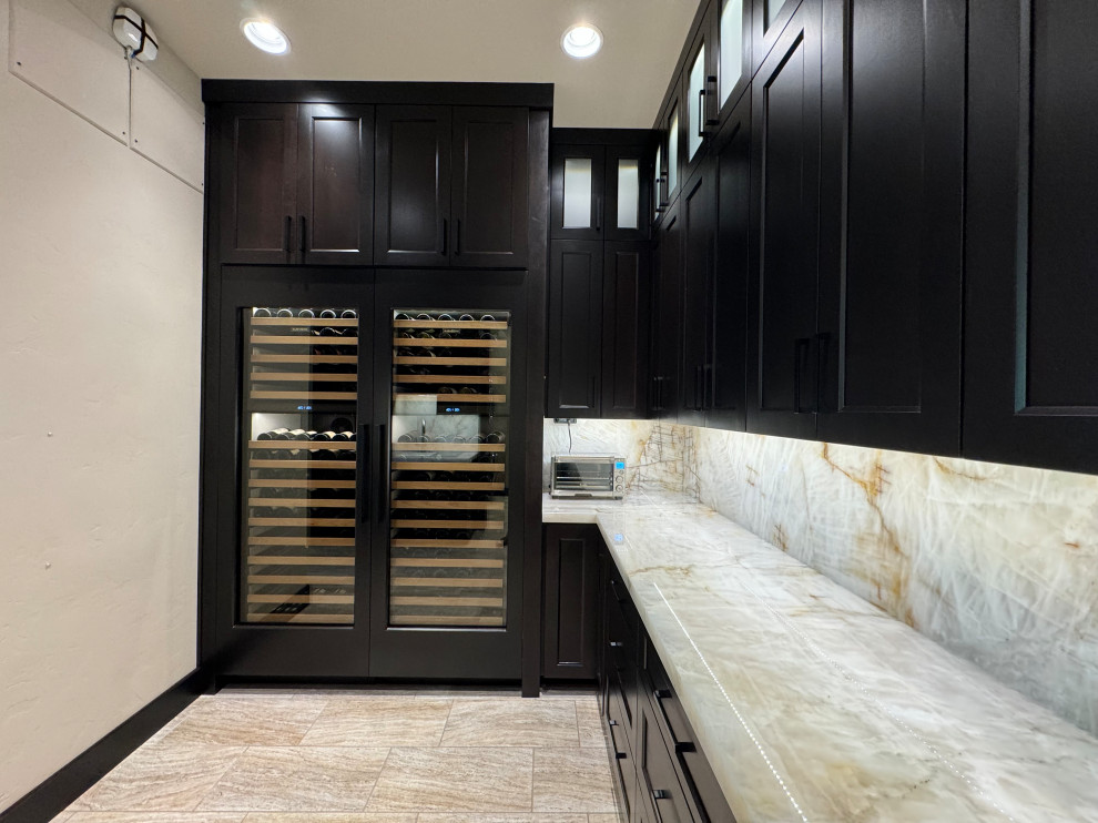Kitchen pantry - large transitional l-shaped porcelain tile and beige floor kitchen pantry idea in Phoenix with an undermount sink, shaker cabinets, dark wood cabinets, quartzite countertops, beige backsplash, stone slab backsplash, paneled appliances, an island and beige countertops