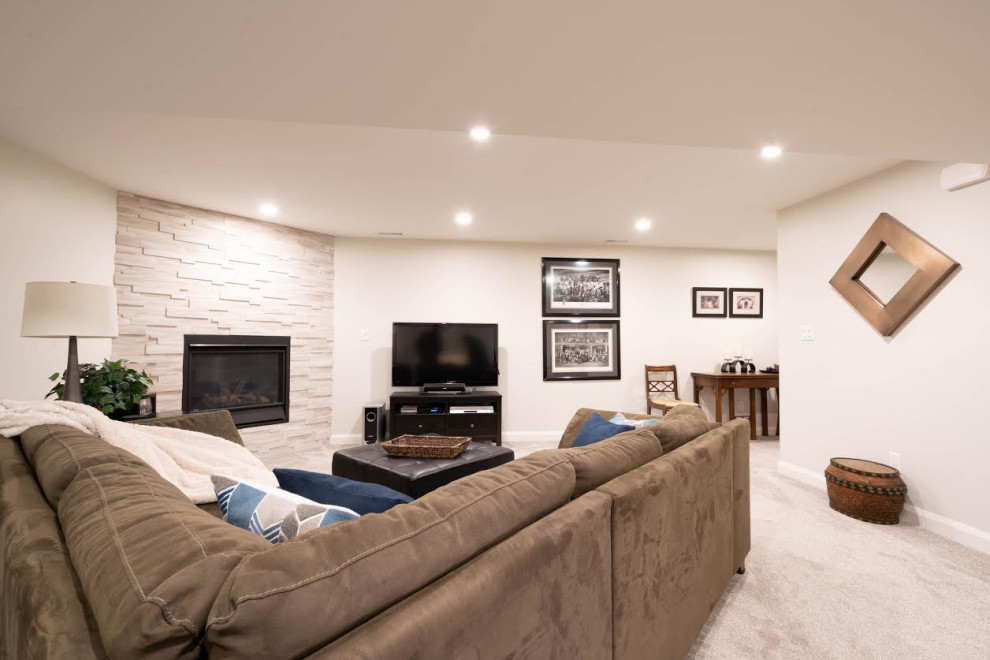 This is an example of a mid-sized midcentury enclosed family room in Calgary with grey walls, carpet, a corner fireplace, a stone fireplace surround, a freestanding tv and grey floor.
