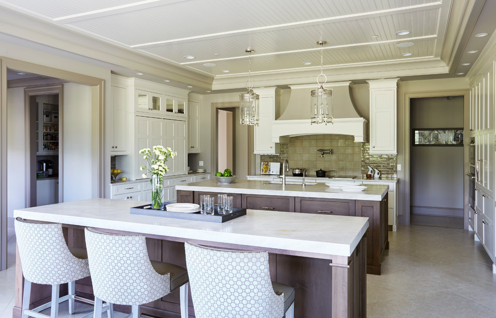 Eat-in kitchen - large transitional u-shaped ceramic tile and gray floor eat-in kitchen idea with a double-bowl sink, raised-panel cabinets, white cabinets, marble countertops, beige backsplash, ceramic backsplash, stainless steel appliances and two islands