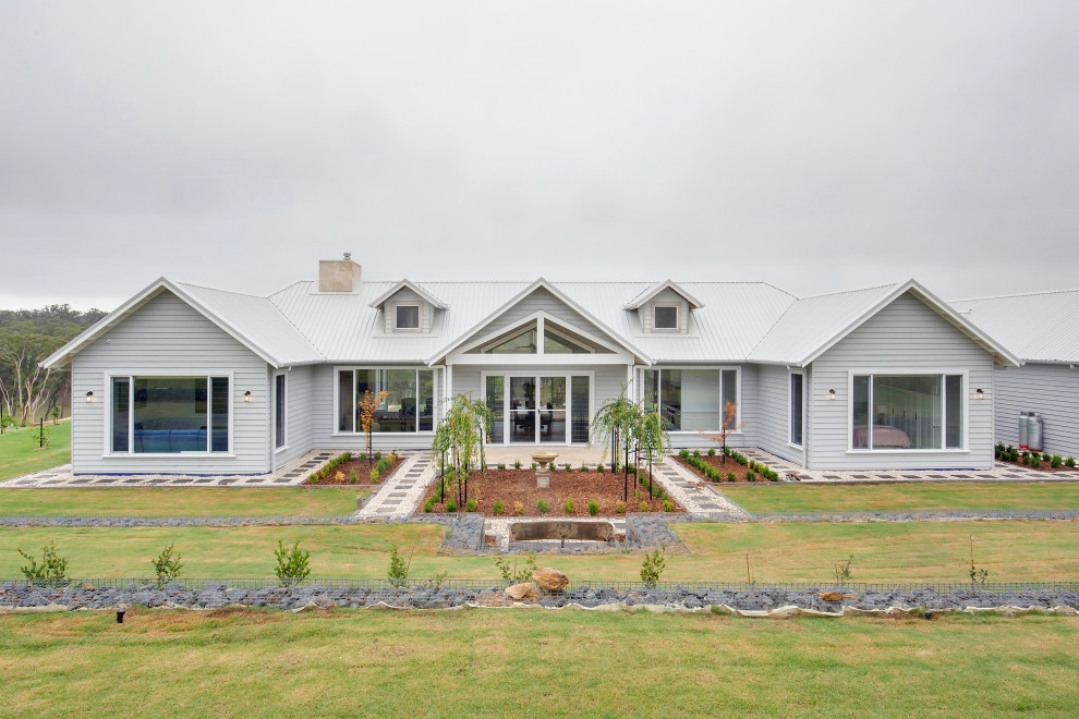 Стильный дизайн: большой, одноэтажный, деревянный, серый частный загородный дом в стиле кантри с металлической крышей и белой крышей - последний тренд