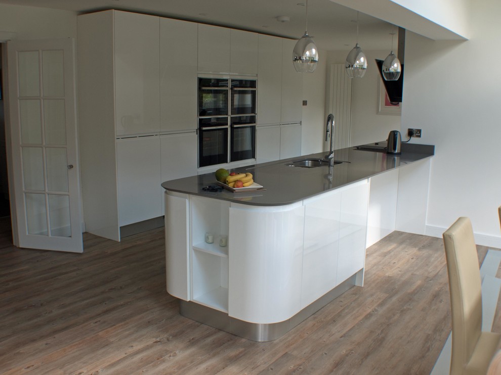 Foto di una grande cucina minimal con lavello sottopiano, ante lisce, ante bianche, top in granito e elettrodomestici da incasso