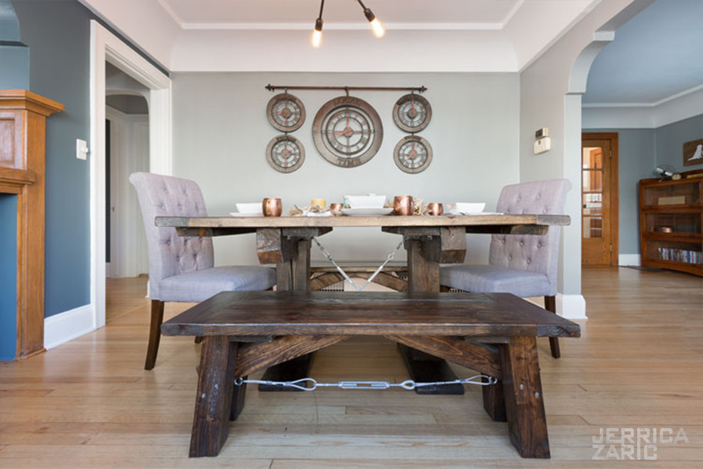 Design ideas for a mid-sized industrial separate dining room with grey walls, light hardwood floors and brown floor.