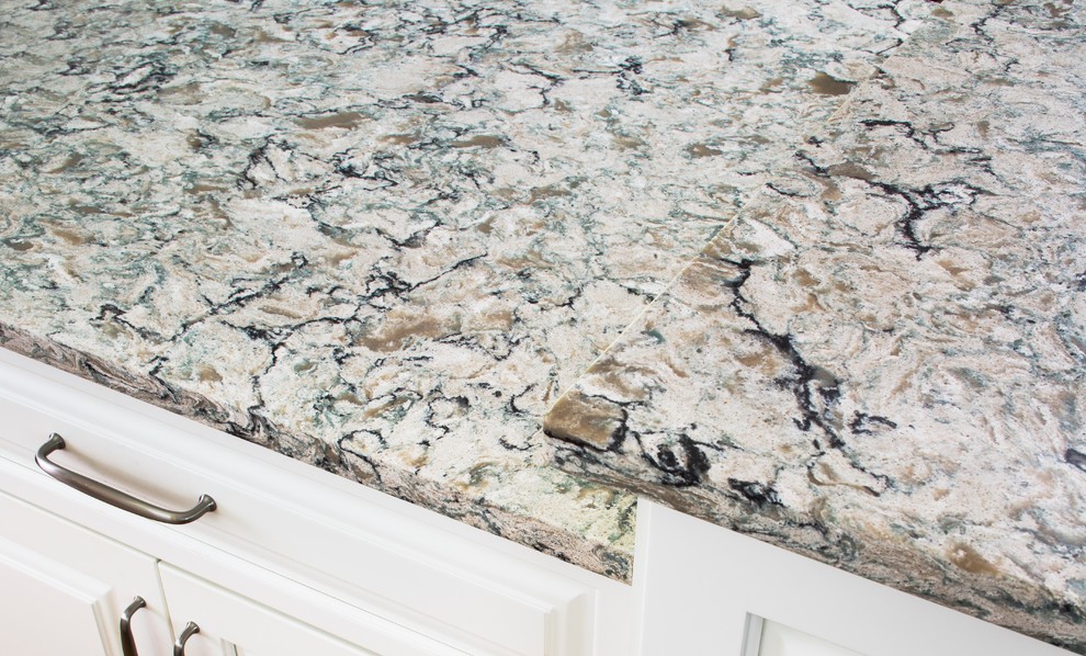 Example of a transitional kitchen design in Atlanta with stainless steel appliances, white cabinets, quartzite countertops and an island
