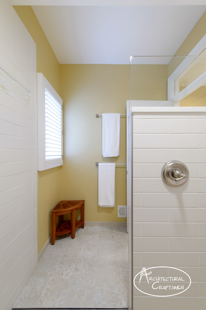 Design ideas for a large traditional master bathroom in Kansas City with an undermount sink, shaker cabinets, dark wood cabinets, glass benchtops, an undermount tub, a curbless shower, white tile, glass tile, yellow walls and porcelain floors.