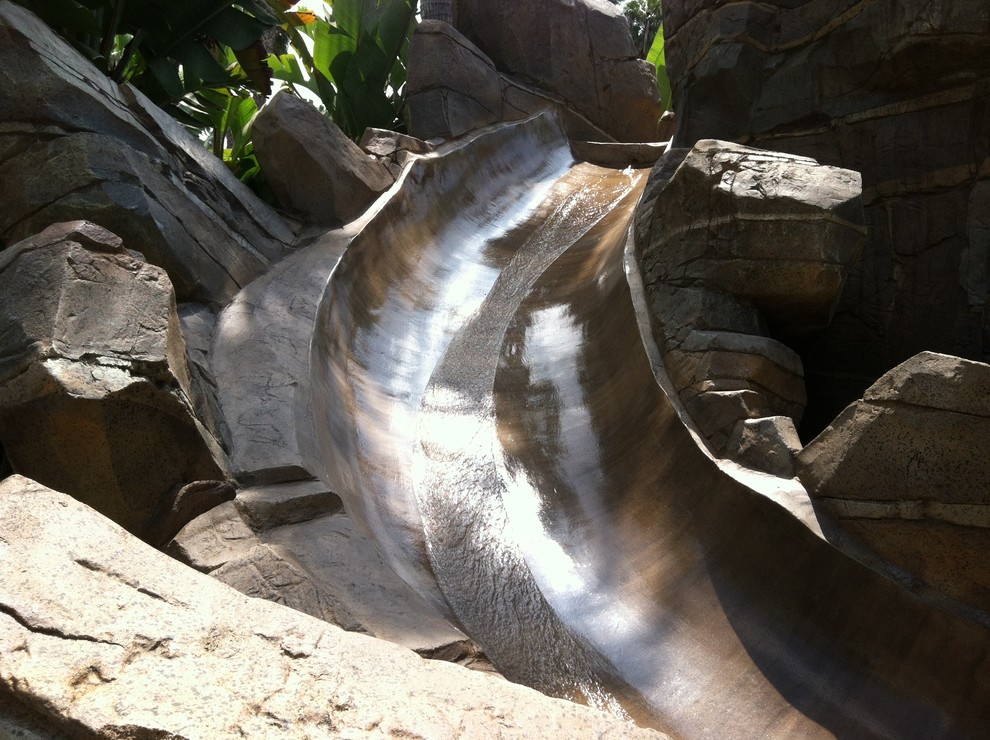 Water slide - rustic backyard custom-shaped natural water slide idea in Orange County