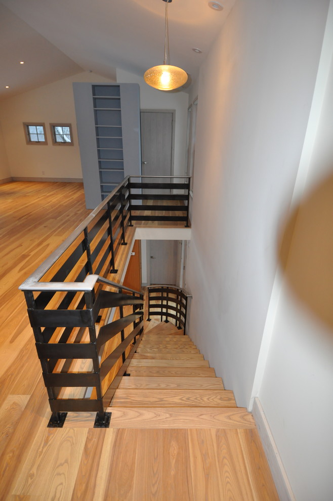 Inspiration for a large transitional wooden curved open and metal railing staircase remodel in Boston