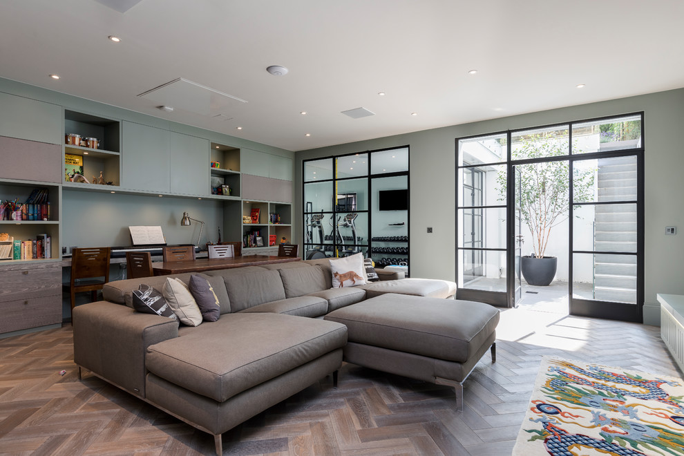 Medium sized contemporary enclosed living room in London with a music area, green walls, medium hardwood flooring, no fireplace and brown floors.