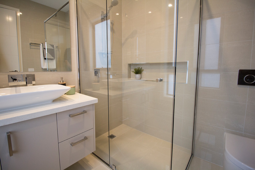 Photo of a small contemporary 3/4 bathroom in Melbourne with a wall-mount toilet, beige tile, porcelain tile, beige walls, cement tiles, concrete benchtops and beige floor.